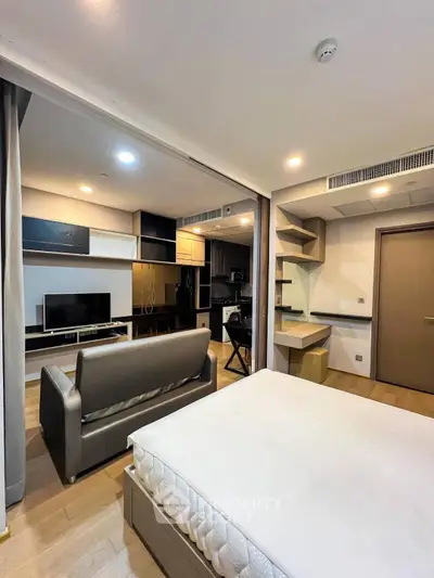 Modern studio apartment with open layout, featuring a cozy living area and stylish built-in furniture.