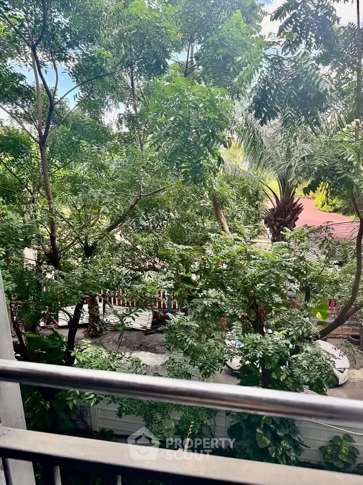 Lush garden view from a balcony with vibrant greenery and serene atmosphere.