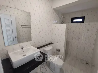 Modern bathroom with sleek white tiles and contemporary fixtures