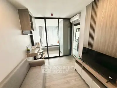 Modern living room with sleek design and glass partition leading to bedroom