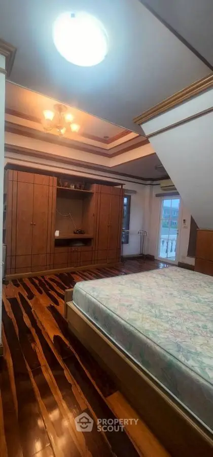 Spacious bedroom with wooden flooring and built-in wardrobe