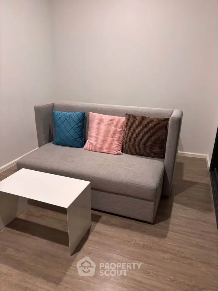 Cozy living room with modern sofa and stylish coffee table on wooden flooring.