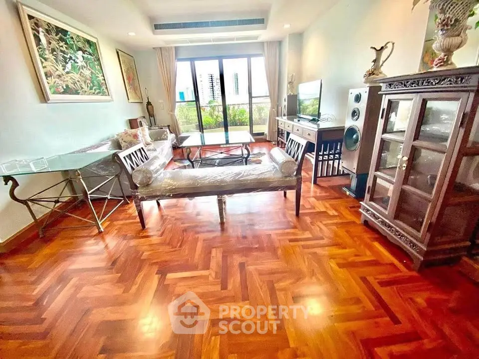 Spacious living room with elegant wooden flooring and stylish furniture, offering a cozy and inviting atmosphere.