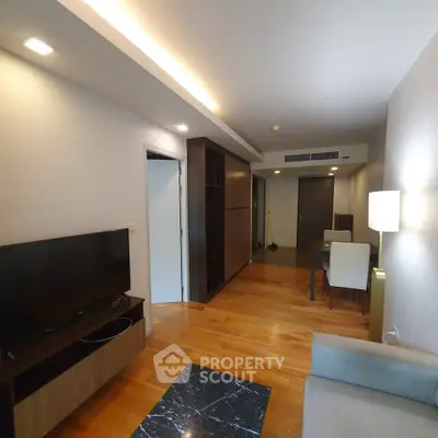 Modern living room with wooden flooring and sleek furniture in a stylish apartment.