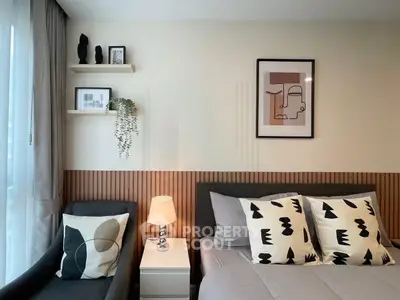 Modern bedroom with stylish decor and cozy ambiance, featuring abstract art and elegant furnishings.