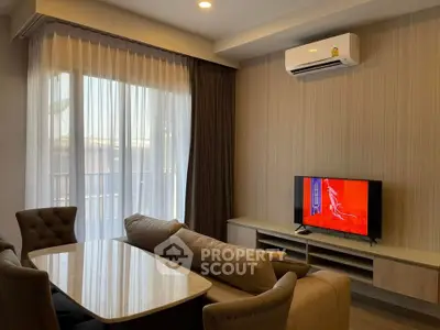 Modern living room with stylish furniture and air conditioning, featuring a large window with curtains.
