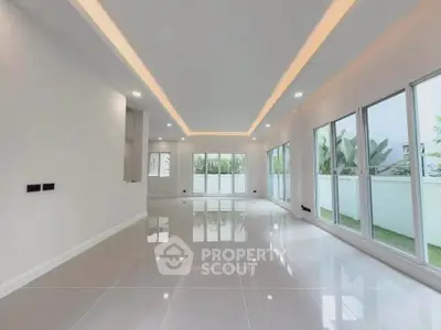 Spacious modern living room with large windows and elegant lighting