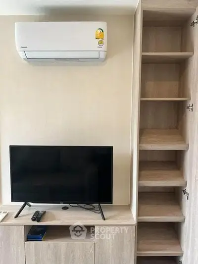 Modern living room with air conditioning and built-in shelving, perfect for compact urban living.