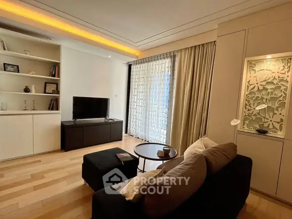 Elegant living room with modern decor, large window, and cozy seating area.