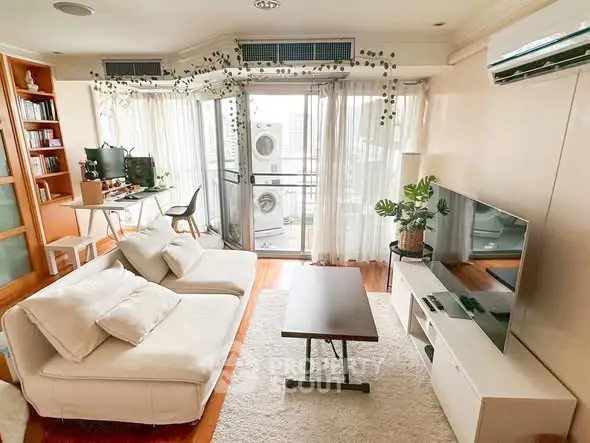 Spacious living room with modern decor and balcony view, featuring cozy seating and entertainment setup.