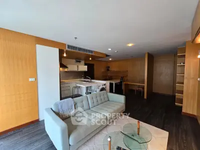 Spacious open-plan living room with modern kitchen and stylish decor in a contemporary apartment.