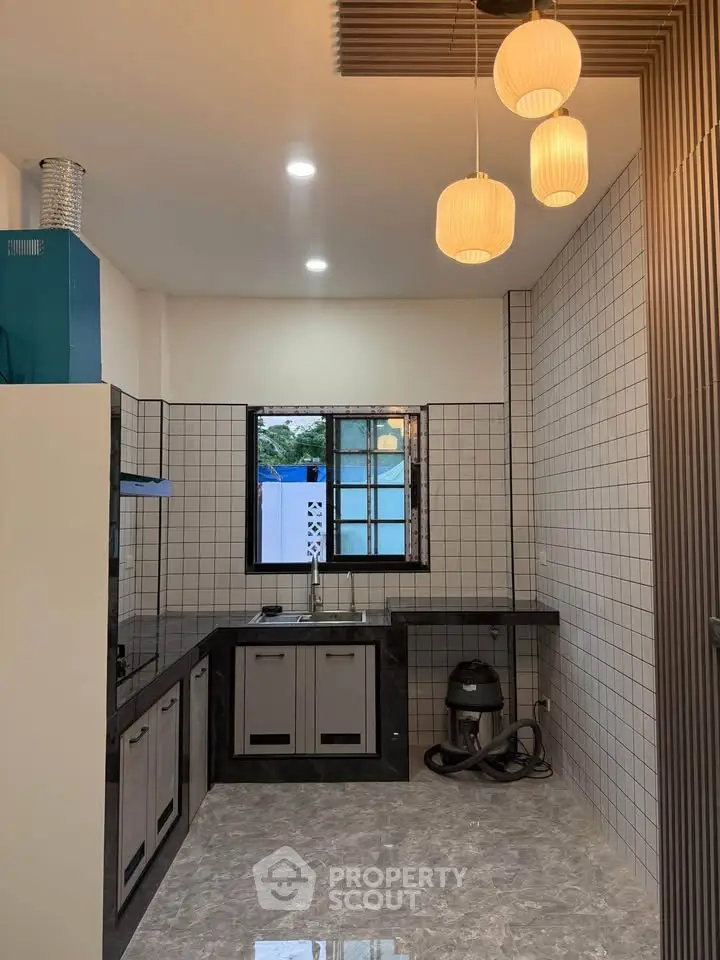 Modern kitchen with sleek black countertops and stylish pendant lighting