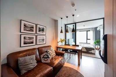 Modern living room with leather sofa and dining area leading to cozy bedroom.