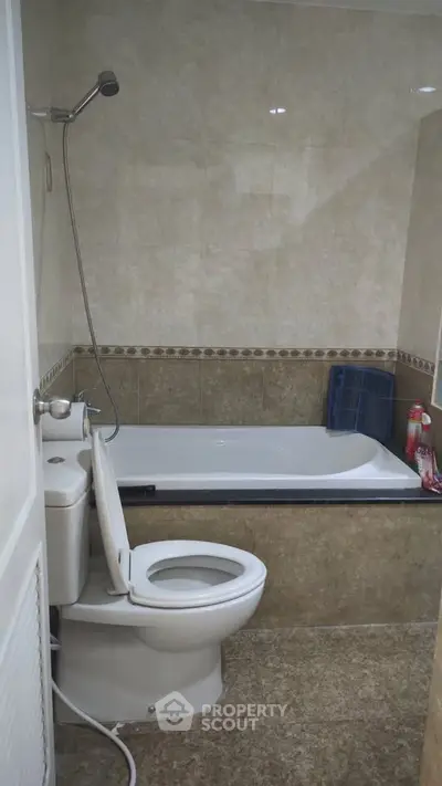 Compact bathroom with bathtub and toilet in modern apartment