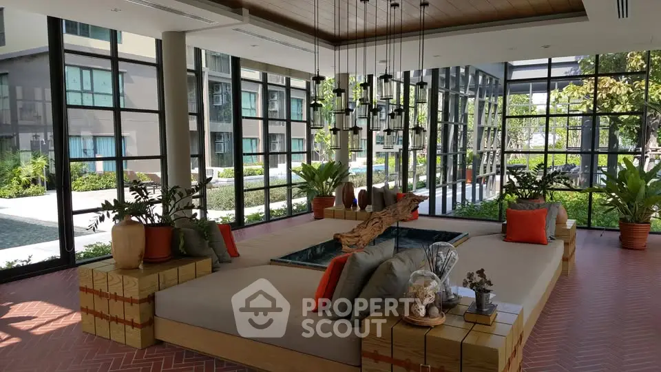 Modern living room with large windows and stylish decor in a luxury apartment complex.