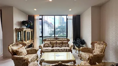 Luxurious living room with elegant gold furniture and large window view