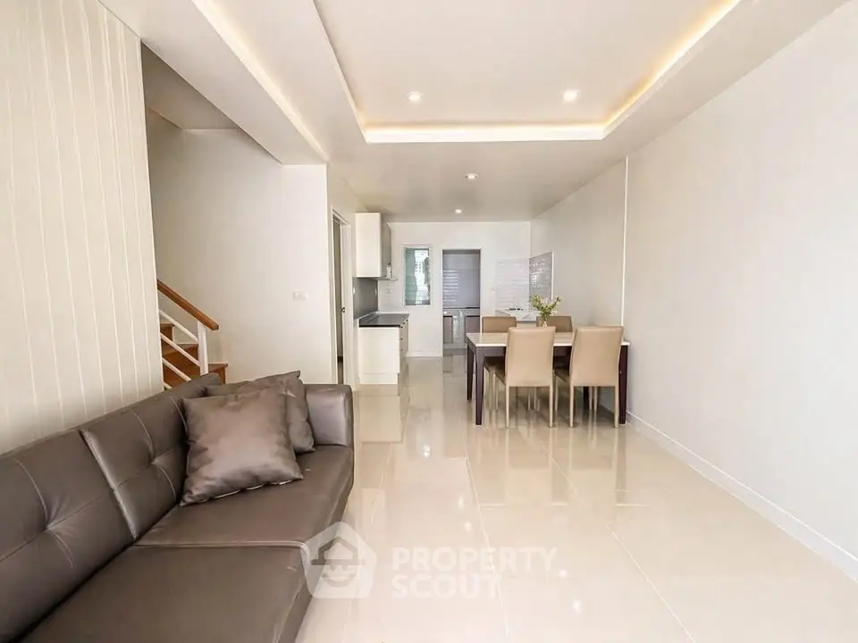 Spacious modern living room with dining area and sleek kitchen in open layout