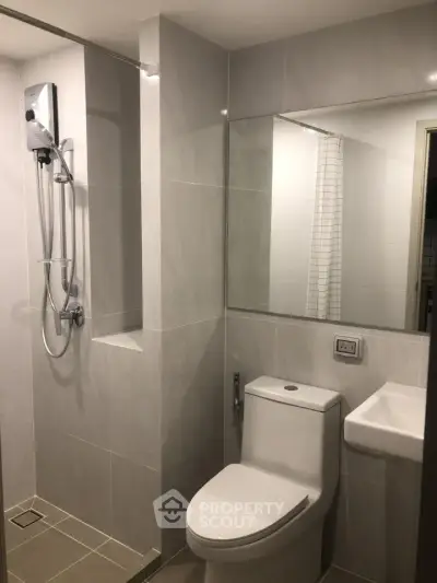 Modern bathroom with sleek fixtures and large mirror in a contemporary apartment.