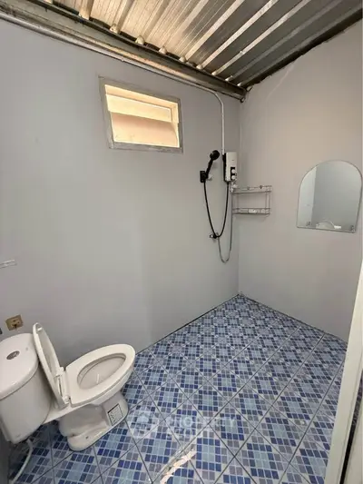 Modern bathroom with blue tiled floor and shower in minimalist design.