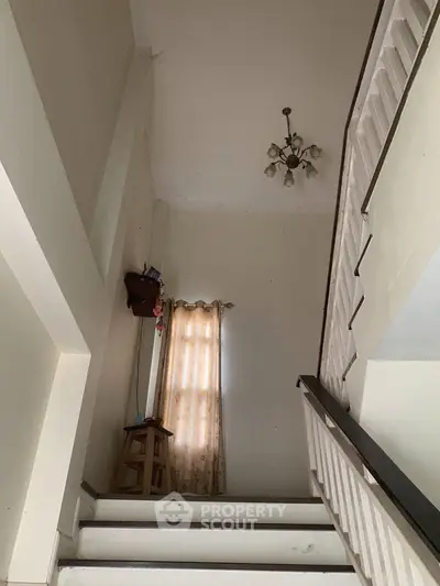 Spacious stairwell with high ceiling and elegant chandelier in a modern home