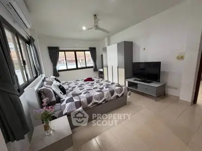 Spacious bedroom with modern decor and large windows offering ample natural light.