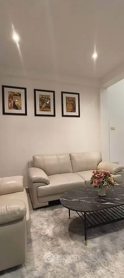 Elegant living room with plush sofas, stylish coffee table, and framed art on the wall.