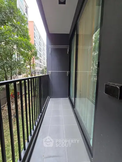 Modern apartment balcony with sleek railing and garden view