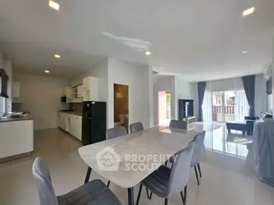 Spacious open-plan living and dining area with modern kitchen and ample natural light.