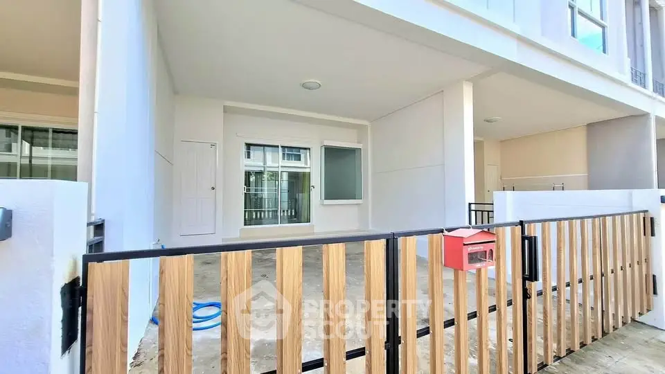 Modern townhouse exterior with wooden fence and spacious patio area.