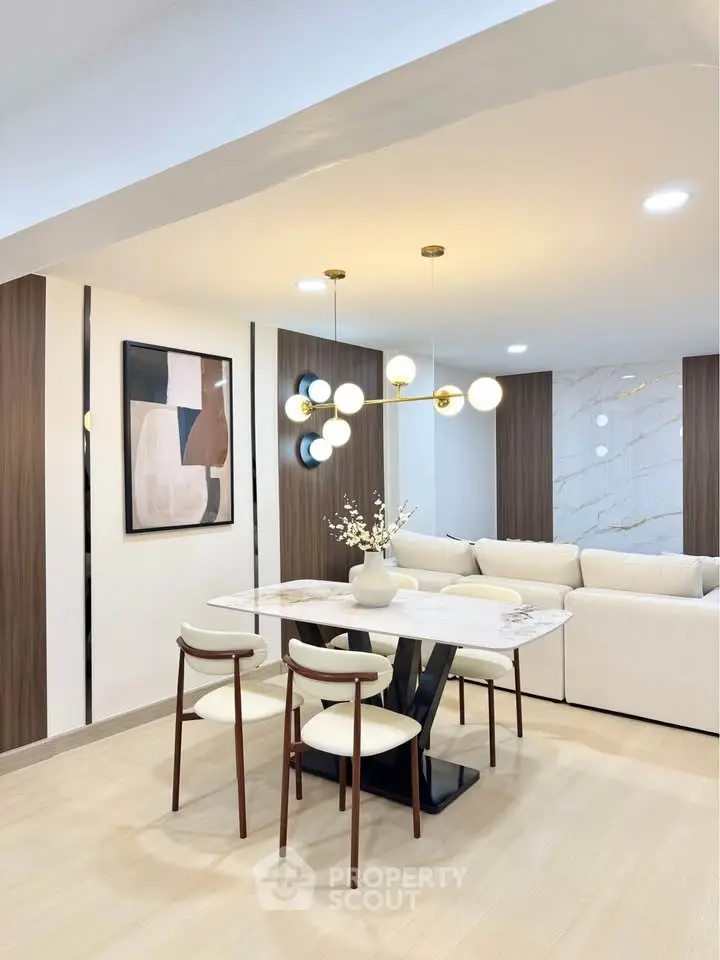 Modern dining area with elegant lighting and stylish decor in a contemporary open-plan living space.