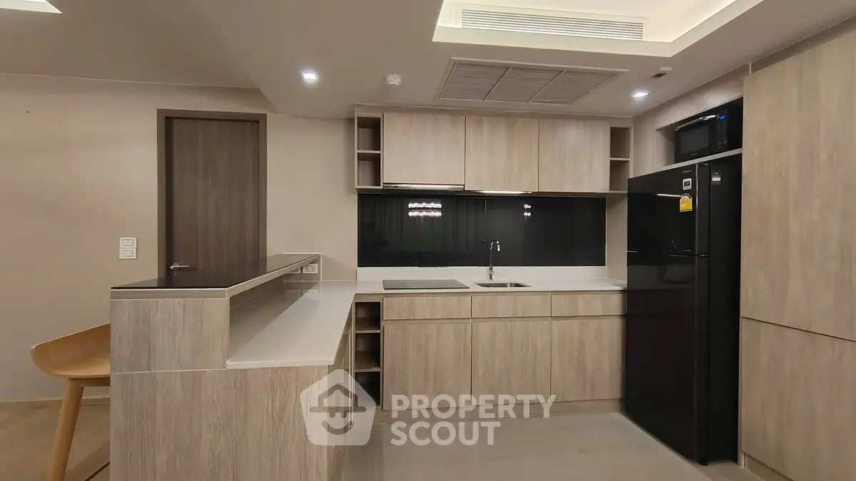 Modern kitchen with sleek cabinetry and black appliances in a stylish apartment