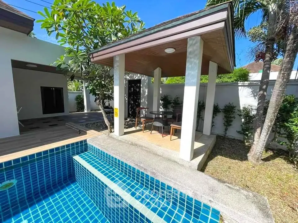 Charming outdoor pool area with a cozy gazebo and lush greenery, perfect for relaxation and entertaining.
