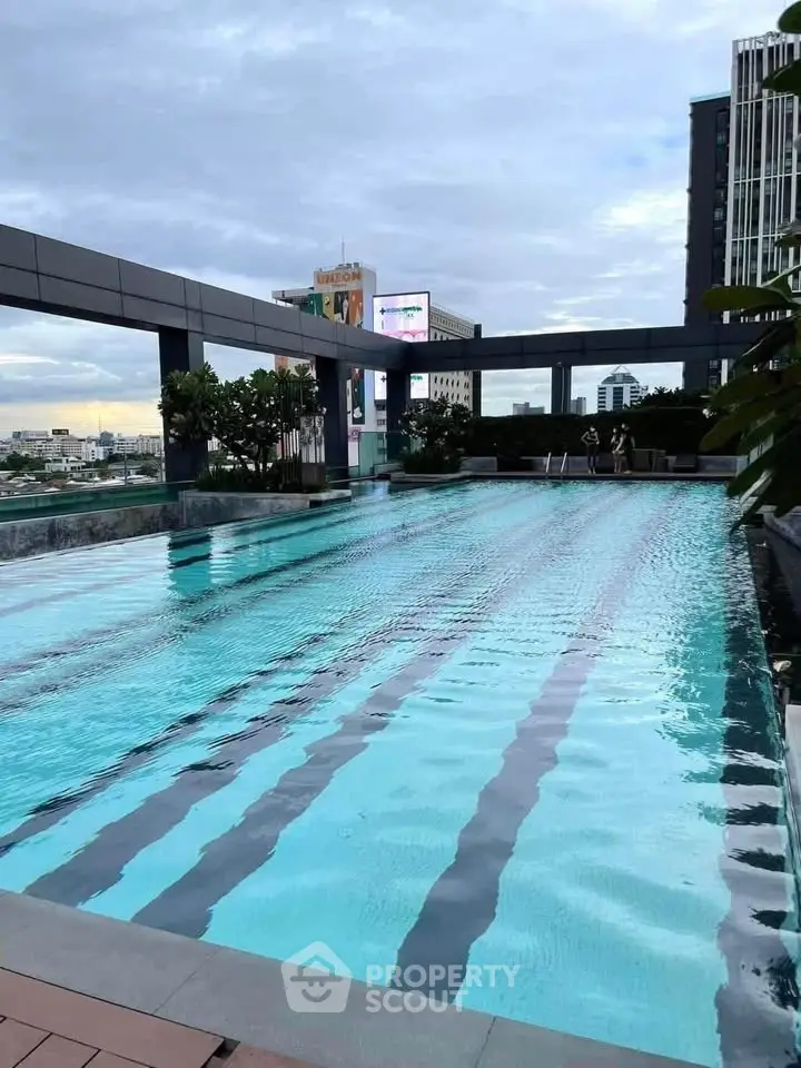 Luxurious rooftop pool with city skyline views in modern high-rise building.