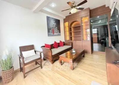 Spacious living room with wooden furniture and ceiling fan in modern apartment.