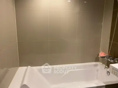 Modern bathroom with sleek bathtub and neutral tile design