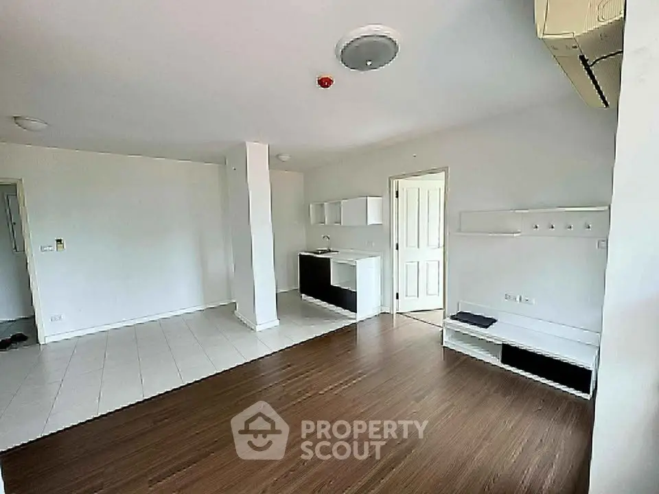 Spacious open-plan living room with modern flooring and built-in storage, ideal for contemporary living.