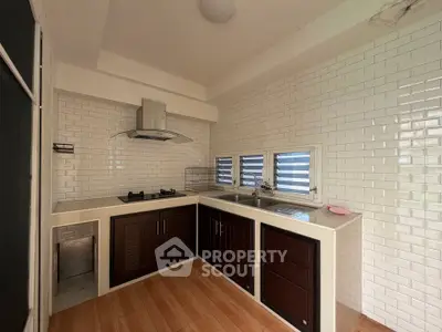 Modern kitchen with sleek cabinetry and gas stove in a bright, tiled space.