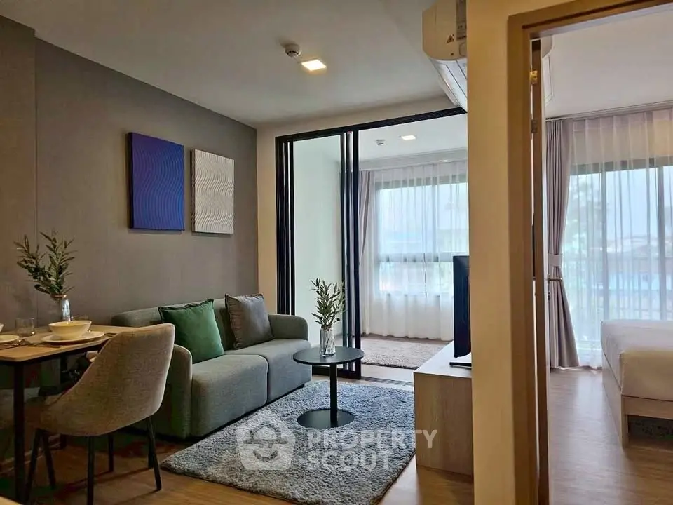 Modern open-plan living room with cozy seating and dining area, featuring stylish decor and natural light.