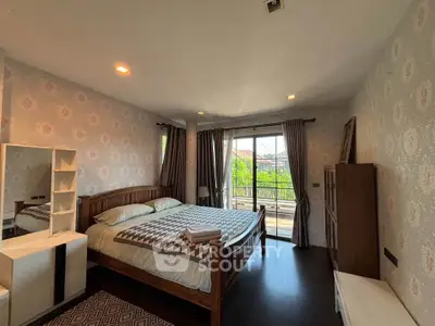 Spacious bedroom with elegant decor and large windows offering a scenic view.
