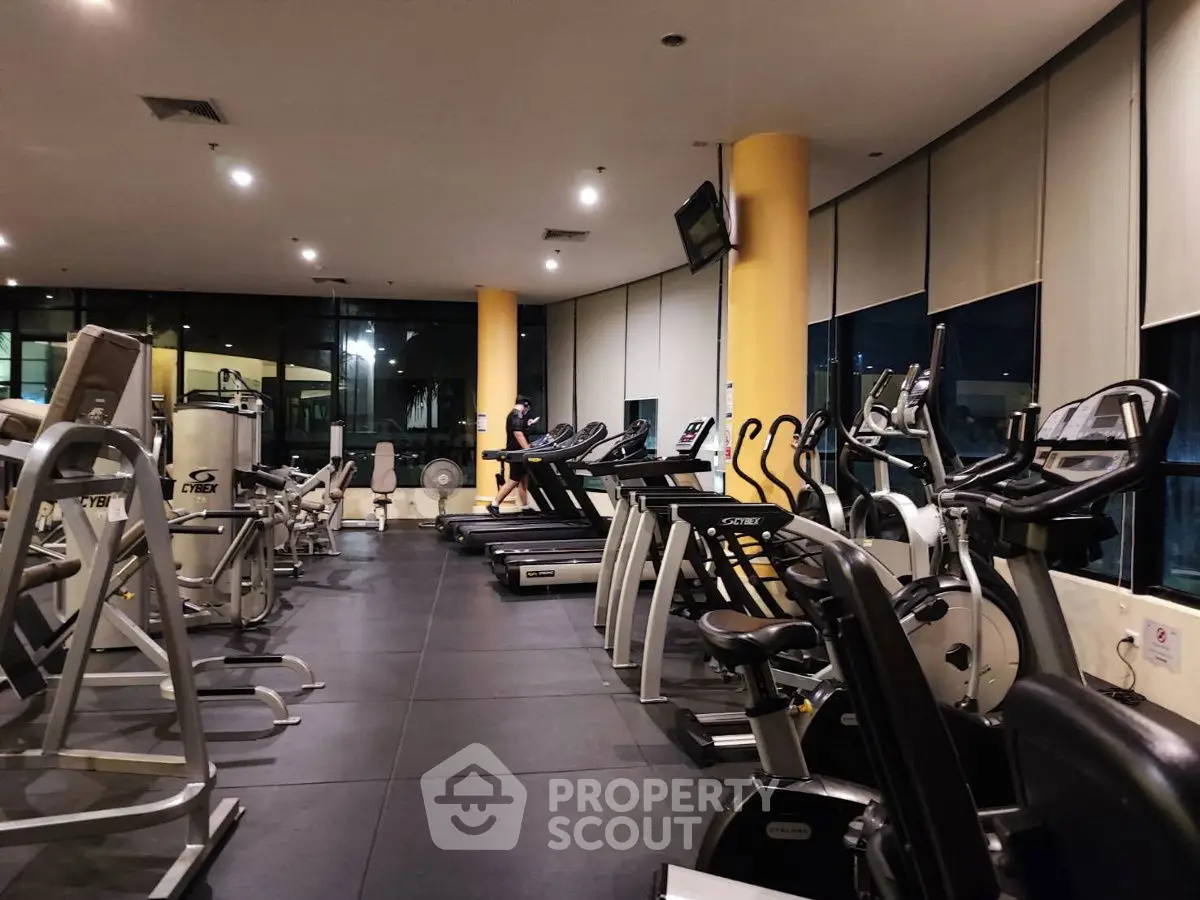 Spacious modern gym with state-of-the-art equipment and large windows.