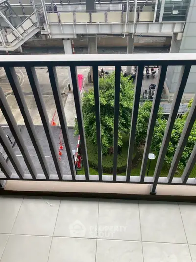 Modern balcony with sleek railing overlooking urban landscape and greenery.