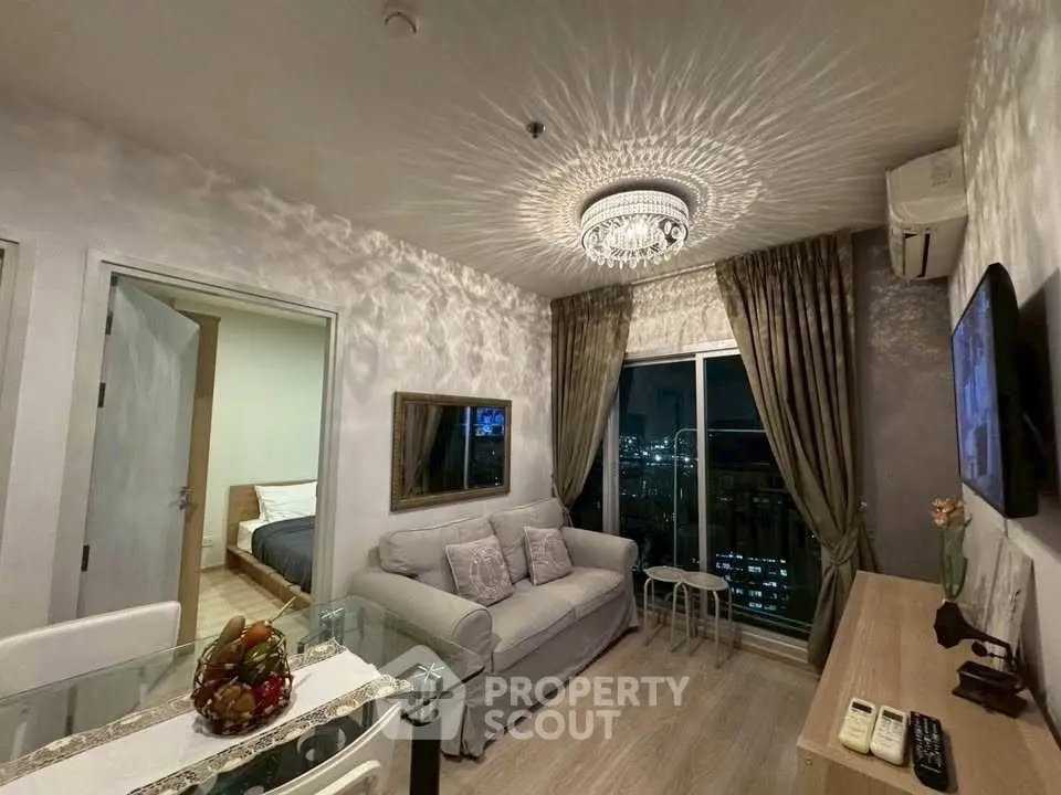 Elegant living room with chandelier and city view, featuring modern decor and cozy ambiance.