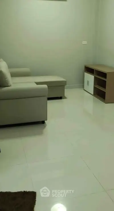 Modern living room with sleek furniture and glossy tiled flooring.