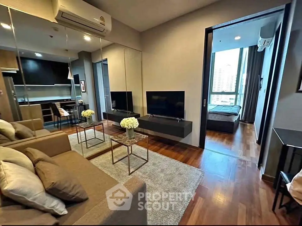 Modern living room with sleek design, hardwood floors, and open view to bedroom, perfect for urban living.