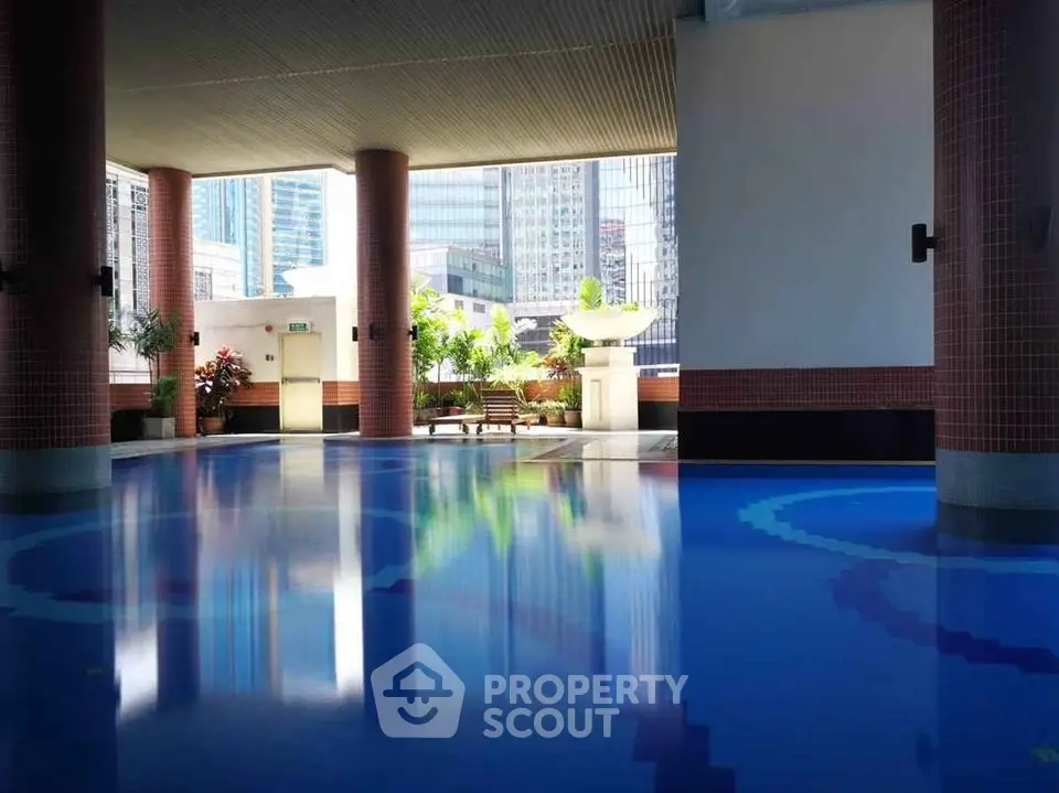 Luxurious indoor pool area with city views and elegant design, perfect for relaxation and leisure.