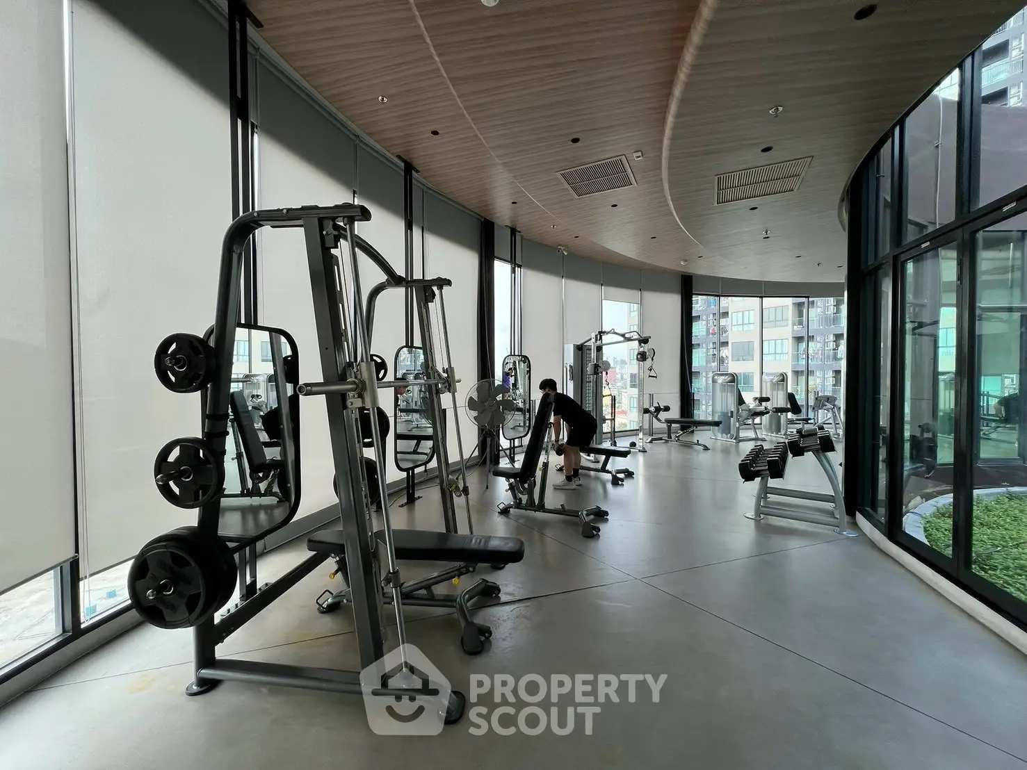 Modern gym with state-of-the-art equipment and large windows offering city views.