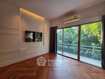 Spacious living room with elegant wood flooring and balcony view