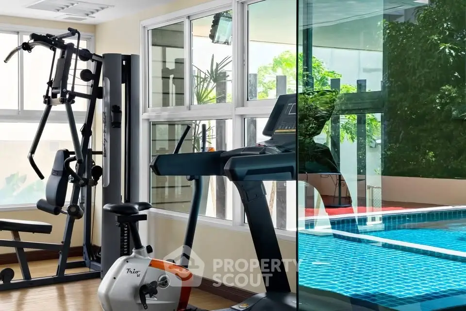 Modern gym with pool view in luxury residential building