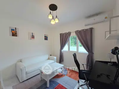 Modern living room with white sofa, desk, and stylish lighting in a bright apartment.