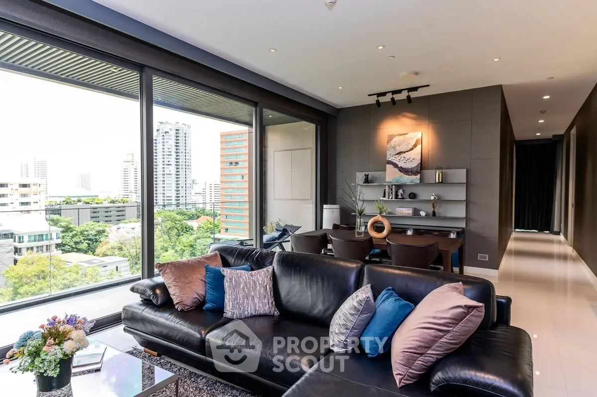 Luxurious living room with sleek black leather sofa, modern decor, and expansive city view through floor-to-ceiling windows, perfect for upscale urban living.